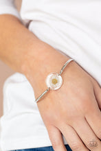 Load image into Gallery viewer, Encased in a glassy fitting, a whimsical white daisy centerpiece attaches to two arcing silver bars around the wrist for an enchanting floral look. Features an adjustable clasp closure. 
