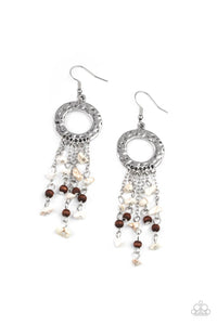 Tapered tassels of dainty wooden beads and white pebbles stream from the bottom of a hammered silver hoop, creating an earthy fringe. Earring attaches to a standard fishhook fitting.