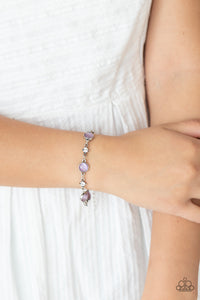 Encased in antiqued silver fittings, dainty white rhinestones and glowing Amethyst Orchid cat's eye stones delicately link around the wrist for a timeless finish. Features an adjustable clasp closure.