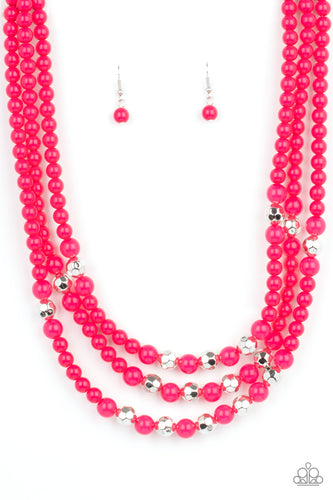 A colorful collection of polished pink beads, faceted silver beads, and opaque pink beads are threaded along invisible wires across the chest, creating vivacious layers. Features an adjustable clasp closure. 