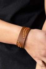 Load image into Gallery viewer, Marigold cording is stitched across the front of a brown leather band, creating curved patterns. Features an adjustable snap closure. 
