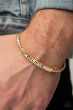 Load image into Gallery viewer, Twisted gold bars attach to a shiny gold plate stamped in the word, &quot;BELIEVE,&quot; creating an inspiring cuff around the wrist.
