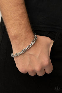 Double linked silver ovals spin into a bold silver chain around the wrist, creating an intense industrial display. Features an adjustable clasp closure.