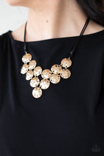 Load image into Gallery viewer, Featuring a hammered finish, a collection of glistening gold discs delicately connect into a netted pendant at the bottom of knotted black cords for a statement-making look. Features an adjustable clasp closure. 
