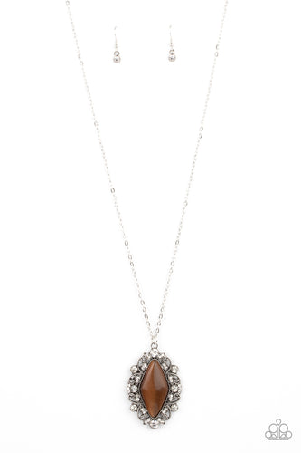 Dotted in glassy white rhinestones, leafy silver filigree blooms from an oversized brown cat's eye stone, creating an enchanted pendant at the bottom of a lengthened silver chain. Features an adjustable clasp closure.