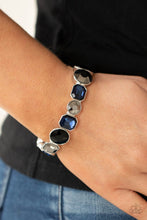 Load image into Gallery viewer, Encased in sleek silver frames, a smoldering collection of round and emerald cut black, blue, and hematite rhinestones glide along stretchy bands around the wrist, creating a sparkly industrial statement piece.
