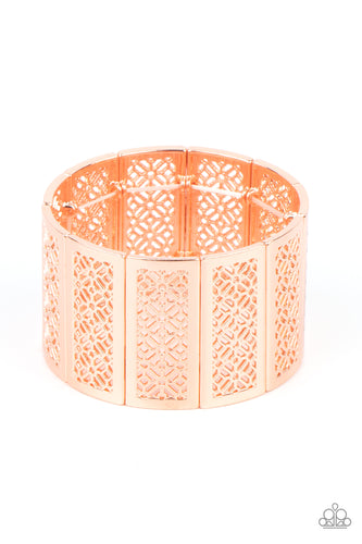 Filled with airy stenciled floral patterns, rectangular shiny copper frames are threaded along stretchy bands around the wrist, creating a whimsical centerpiece.