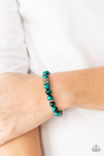 Load image into Gallery viewer, An earthy collection of glassy green and black beads, textured silver rings, and floral embossed beads are threaded along stretchy bands around the wrist, creating a seasonal centerpiece
