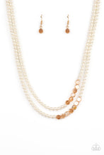 Load image into Gallery viewer, A posh collection of pearly white beads, accented with sections of flat, faceted shimmery transparent gold beads, is threaded along invisible wires, creating sophisticated layers that fall below the collar. Features an adjustable clasp closure.
