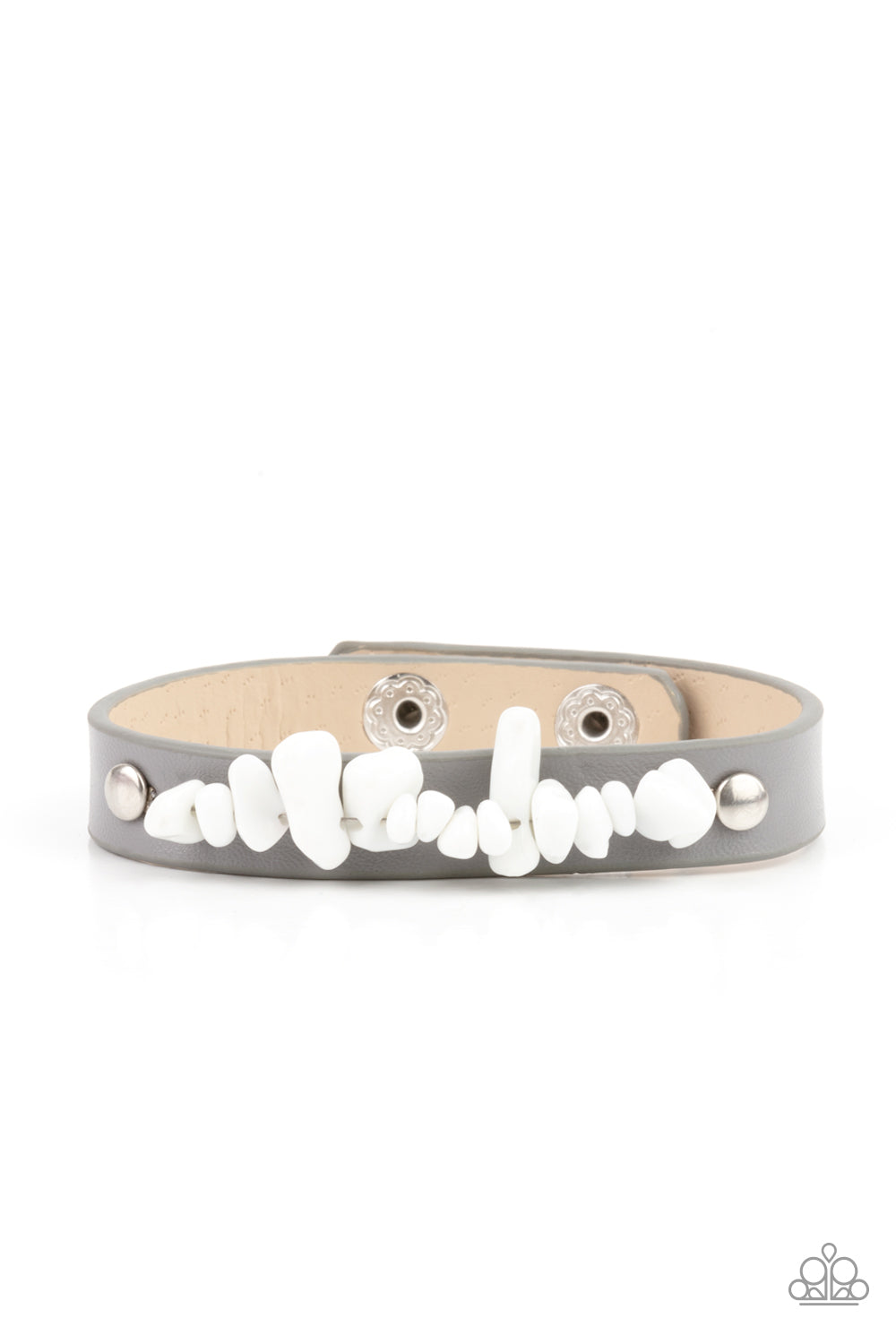A strand of white pebbles is studded in place across the front of a skinny gray leather band, creating a colorful earthy display around the wrist. Features an adjustable snap closure.