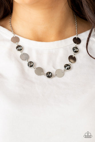Shiny silver discs and oversized smoky gems delicately link below the collar, creating a sparkly statement piece. Features an adjustable clasp closure.  Sold as one individual necklace. Includes one pair of matching earrings.