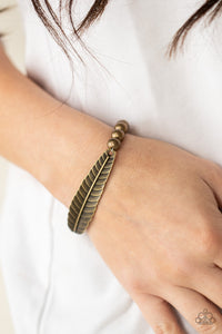 Infused with a lifelike brass feather frame, a row of rustic brass beads are threaded along stretchy bands around the wrist for a seasonal fashion.