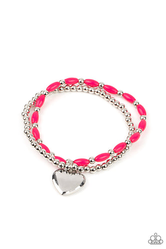A bright silver heart dangles from a strand of playful Raspberry Sorbet beads.  It is paired with a strand of round silver beads threaded along a stretchy band for a whimsical display around the wrist. 
