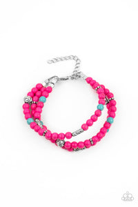 A collection of pink and turquoise stone beads, silver cube beads, and ornate silver accents are threaded along invisible bands around the wrist, creating vivacious layers. Features an adjustable clasp closure.