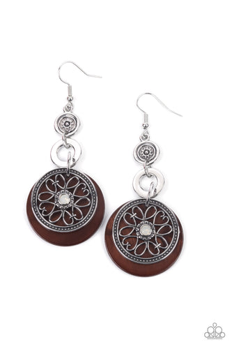 Reminiscent of an eclipse, an airy silver ring radiating with ornate petals, sways in front of a brown shell-like disc. Silver rings in graduating sizes cascade from the top for a whimsically nautical look. Earring attaches to a standard fishhook fitting.