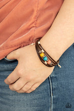 Load image into Gallery viewer, Infused with studded silver accents, a row of Desert Mist, Blue Tint, and Illuminating cat&#39;s eye stone beads adorn the centermost strand of layered leather bands around the wrist for a colorful seasonal look. Features an adjustable sliding knot closure.
