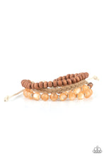 Load image into Gallery viewer, Strands of glassy orange cat&#39;s eye beads stand out in an earthy collection of wooden beads and braided twine, giving a polished flair to the natural homespun look as it stacks up the wrist. Features an adjustable sliding knot closure. 
