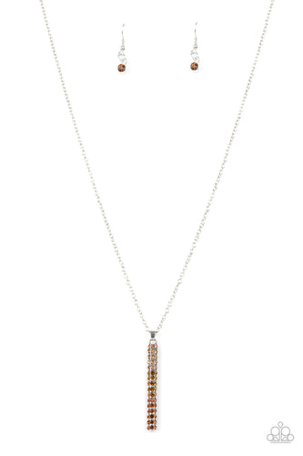 A sparkly collection of light, golden, and classic topaz rhinestones are encrusted along a silver pendulum that swings along the bottom of a silver chain, creating a glittery ombre effect. Features an adjustable clasp closure.