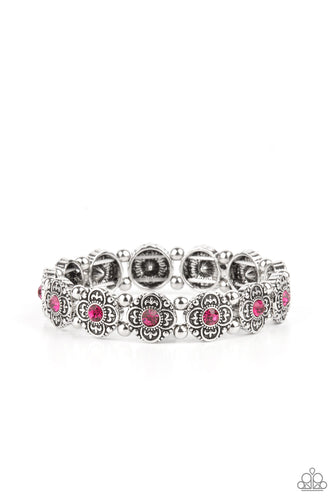 Dotted with glittery pink rhinestone centers, antiqued silver floral frames and dainty silver beads are threaded along stretchy bands around the wrist for a seasonal twist.