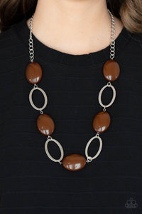 Shiny silver ovals and glassy brown oval beads delicately link across the chest, creating a whimsical pop of color. Features an adjustable clasp closure.