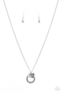 Dotted with a sparkly pink rhinestone, a dainty silver heart joins a silver ring stamped in the biblical passage, "Trust in the Lord with all thine heart," and a silver disc stamped in, "Proverbs 3:5," along the bottom of a lengthened silver chain, creating an inspirational pendant. Features an adjustable clasp closure.