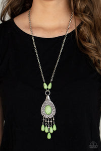 An Apple Green oval stone sits center stage surrounded by swirly designs stamped into a wide silver frame. A fringe of silver floral beads culminating in Apple Green stones swings like a pendulum at the end of a lengthened silver chain for a fashionable finish. Features an adjustable clasp closure.