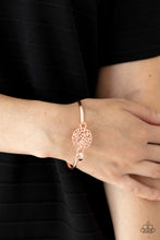 Load image into Gallery viewer, Shiny rose gold filigree swirls into a round frame that hooks to a dainty rose gold bangle-like cuff, creating a whimsical centerpiece. Features a hinge-like closure.
