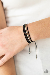 A single accent strand of silver beads merges with multiple strands of micro black beads for a simple yet trendy look. Features an adjustable sliding knot closure.