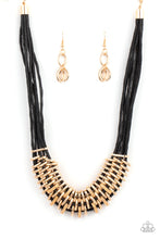 Load image into Gallery viewer, Bold and unapologetic, this hefty necklace gives off a hand-made feel with its multiple strands of black cording held together by industrial gold fittings that shift and slide. Features an adjustable clasp closure.
