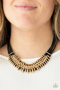 Bold and unapologetic, this hefty necklace gives off a hand-made feel with its multiple strands of black cording held together by industrial gold fittings that shift and slide. Features an adjustable clasp closure.