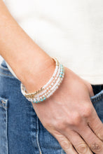 Load image into Gallery viewer, Sections of pearly white seed beads alternate with gold, turquoise, and crystal-like beads in infinite rows. The dreamy colors are threaded along a continuous strand of wire for an infinity wrap-style bracelet around the wrist
