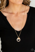 Load image into Gallery viewer, Dotted with a sparkly white rhinestone, a dainty gold heart joins a gold ring stamped in the biblical passage, &quot;Trust in the Lord with all thine heart,&quot; and a gold disc stamped in, &quot;Proverbs 3:5,&quot; along the bottom of a lengthened gold chain, creating an inspirational pendant. Features an adjustable clasp closure.
