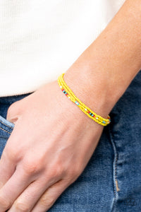 Two strands of dainty Illuminating seed beads, highlighted with a strand of brightly colored beads, form a simple accent around the wrist. Features an adjustable sliding knot closure.