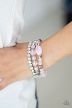 Load image into Gallery viewer, Infused with a stretchy strand of glassy white rhinestones, a mismatched collection of cloudy pink, white crystal-like, and ornate silver accents are threaded along stretchy bands around the wrist, creating ethereal layers. 
