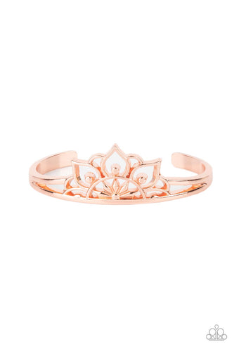 Brushed in a high sheen finish, an airy mandala-like frame crowns the top of a dainty shiny copper cuff for a whimsically seasonal flair.