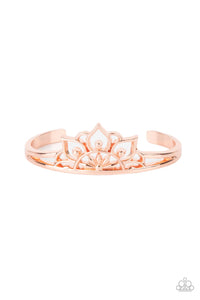Brushed in a high sheen finish, an airy mandala-like frame crowns the top of a dainty shiny copper cuff for a whimsically seasonal flair.