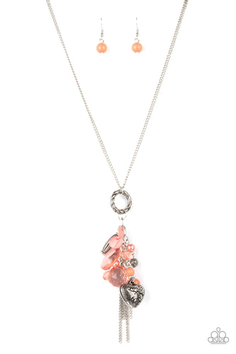 Varying glassy, pearly, opaque, and shell-like finishes, a whimsical collection of crystal-like and classic Burnt Coral beads delicately cluster along a chunky silver chain swinging from the bottom of a textured silver ring. Mismatched silver beads, classic silver chains, and a decorative silver locket-like bead are added to the fringe, creating an enchanted tasseled pendant at the bottom of a classic silver chain. Features an adjustable clasp closure. 