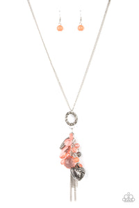 Varying glassy, pearly, opaque, and shell-like finishes, a whimsical collection of crystal-like and classic Burnt Coral beads delicately cluster along a chunky silver chain swinging from the bottom of a textured silver ring. Mismatched silver beads, classic silver chains, and a decorative silver locket-like bead are added to the fringe, creating an enchanted tasseled pendant at the bottom of a classic silver chain. Features an adjustable clasp closure. 