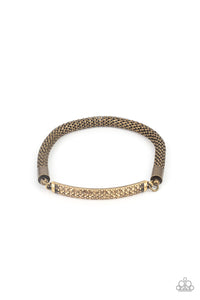 Threaded along a stretchy band, a gritty strand of rounded brass mesh chain links with a smoldering brass plate encrusted in rows of dainty topaz rhinestones, creating an edgy shimmer around the wrist.