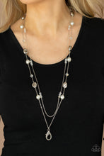 Load image into Gallery viewer, A dainty silver chain adorned in trios of iridescent flecked crystal-like beads layers with a chain dotted with matching crystal-like accents and imperfect silver and pearly white beads across the chest for a refined flair. A lobster clasp hangs from the bottom of the design to allow a name badge or other item to be attached. Features an adjustable clasp closure.  Sold as one individual lanyard. Includes one pair of matching earrings.
