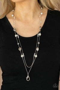 A dainty silver chain adorned in trios of iridescent flecked crystal-like beads layers with a chain dotted with matching crystal-like accents and imperfect silver and pearly white beads across the chest for a refined flair. A lobster clasp hangs from the bottom of the design to allow a name badge or other item to be attached. Features an adjustable clasp closure.  Sold as one individual lanyard. Includes one pair of matching earrings.