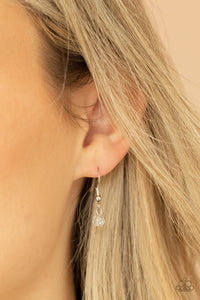 A dainty silver chain adorned in trios of iridescent flecked crystal-like beads layers with a chain dotted with matching crystal-like accents and imperfect silver and pearly white beads across the chest for a refined flair. A lobster clasp hangs from the bottom of the design to allow a name badge or other item to be attached. Features an adjustable clasp closure.  Sold as one individual lanyard. Includes one pair of matching earrings.