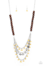 Load image into Gallery viewer, Adorned with yellow pebbles and hammered silver discs, three silver chains layer from strands of brown wooden beads, creating an earthy fringe below the collar. Features an adjustable clasp closure.
