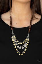 Load image into Gallery viewer, Adorned with yellow pebbles and hammered silver discs, three silver chains layer from strands of brown wooden beads, creating an earthy fringe below the collar. Features an adjustable clasp closure.
