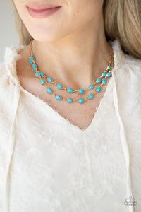 Encased in studded gold frames, two rows of oval turquoise stones delicately connect below the collar for a seasonal flair. Features an adjustable clasp closure. 