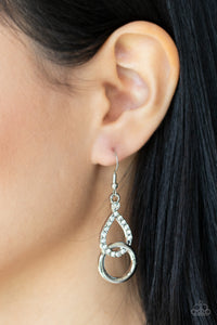 A glittery white rhinestone teardrop frame links with a shiny silver ring, creating a timeless lure. Earring attaches to a standard fishhook fitting. 