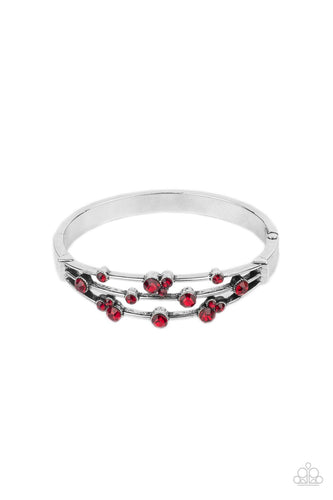A smattering of fiery red rhinestones adorn three silver bars that coalesce into a versatile silver cuff-like bangle around the wrist. Features a hinged closure.