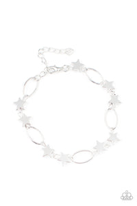 Dainty silver stars and airy silver ovals delicately link around the wrist, creating a stellar 4th of July display. Features an adjustable clasp closure.