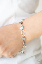 Load image into Gallery viewer, Dainty silver stars and airy silver ovals delicately link around the wrist, creating a stellar 4th of July display. Features an adjustable clasp closure.
