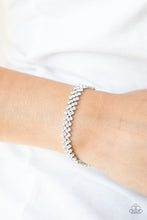 Load image into Gallery viewer, Featuring sleek silver fittings, dainty rows of glassy white rhinestones delicately slant across the wrist, coalescing into a timeless centerpiece. Features an adjustable clasp closure. 
